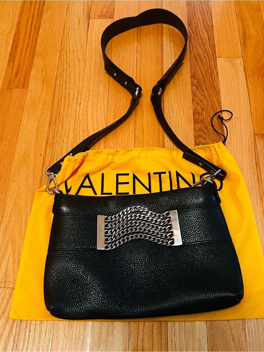 Black Mario Valentino leather crossbody bag featuring silver chain detailing.